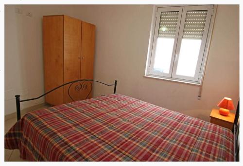 a bedroom with a bed and a dresser and a window at Villette Ninfee in Marina di Mancaversa