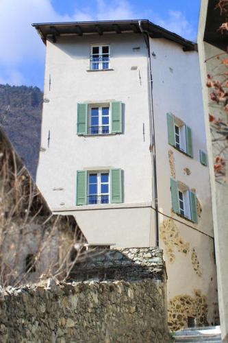 un bâtiment avec des fenêtres vertes et blanches sur un mur dans l'établissement Antica Torre, à Sondrio