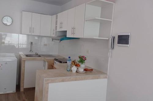 a kitchen with white cabinets and a counter top at Chicama D'Amore Dpto Familiar Kids & Wave on PtoMalabrigo in Puerto Chicama