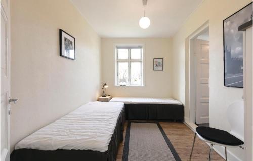 Habitación pequeña con 2 camas y ventana en 2 Bedroom Cozy Home In Gudhjem, en Gudhjem