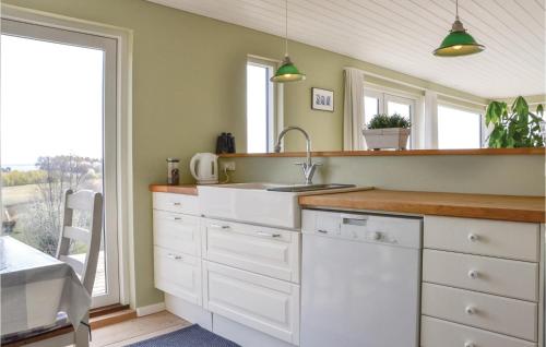 a kitchen with white cabinets and a sink and a window at Lovely Home In Skibby With Wifi in Skibby