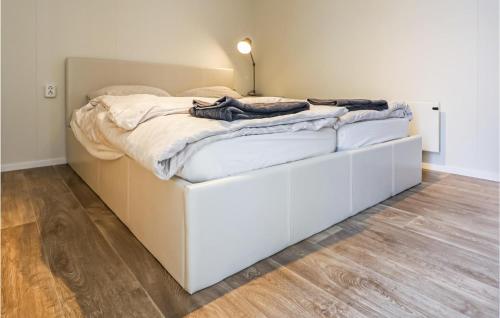 ein weißes Bett auf einem Holzboden in der Unterkunft Aqualiving in Leimuiden
