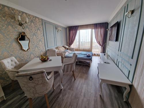 Una sala de estar con una mesa y sillas y una cama. en FS Apartments - Modern Sea-View Apt - First Line, en Golden Sands