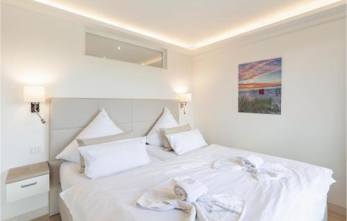 a bedroom with a white bed with white pillows at Pearl in Binz