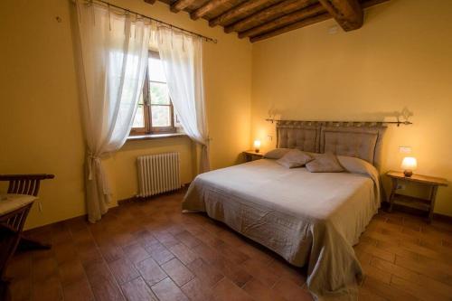 Un dormitorio con una cama grande y una ventana en Casetta della Pina en Monticiano
