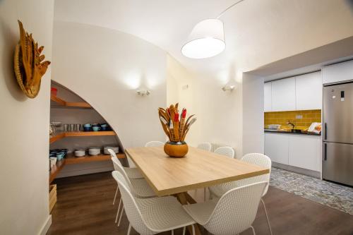uma cozinha e sala de jantar com uma mesa de madeira e cadeiras em Evora Spot Rooms em Évora