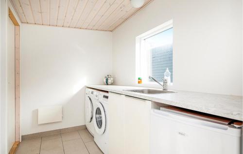 ロッケンにあるNice Home In Lkken With 4 Bedrooms, Sauna And Wifiの白いキッチン(シンク、洗濯機付)