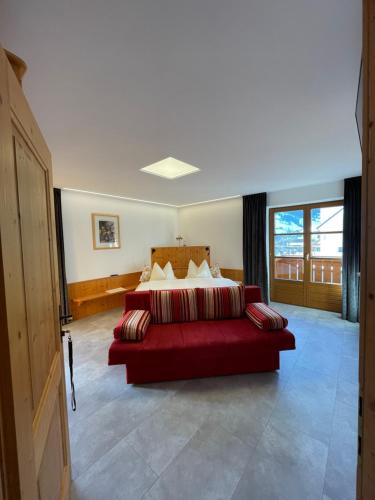 a bedroom with a red bed and a red couch at Ferienhaus Zentral in Wagrain