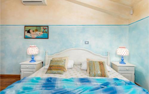 a bedroom with a bed with blue walls and two lamps at Nice Home In Valtura With Kitchen in Valtura