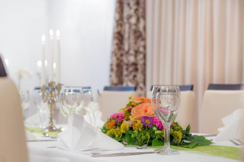 a table with wine glasses and a bouquet of flowers at Kulinarium an der Glems in Stuttgart