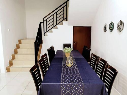a dining room with a blue table and some stairs at Botani Tmn Cyber Ipoh(24 pax /tv box/mahjong) in Ipoh