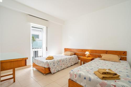 a bedroom with two beds and a balcony at Edifício Sequeira - Alojamento Local by Umbral in Albufeira