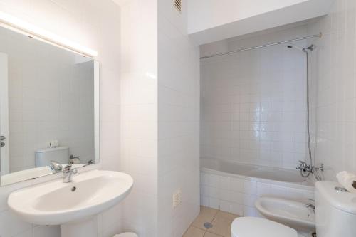 a white bathroom with a sink and a toilet at Edifício Sequeira - Alojamento Local by Umbral in Albufeira