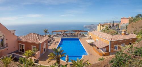 an aerial view of a house with a swimming pool at Sea and Sun 4 You - Palheiro Village in Funchal