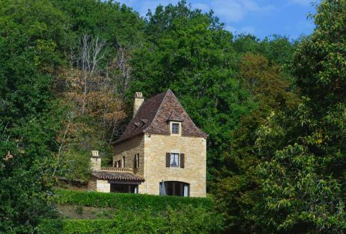 une vieille maison en pierre sur une colline dans les bois dans l'établissement Roquecombe, à La Roque-Gageac