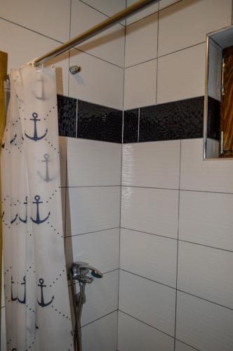 a shower with an anchor shower curtain in a bathroom at Vila Alić in Šišava