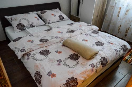 a bed with a comforter and pillows on it at Vila Alić in Šišava