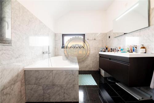 a bathroom with a tub and a sink and a mirror at VILA ORADEA LUX in Oradea