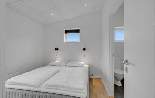 4 Bedroom Gorgeous Home In Lgstrup في Løgstrup: غرفة نوم بيضاء مع سرير وحمام
