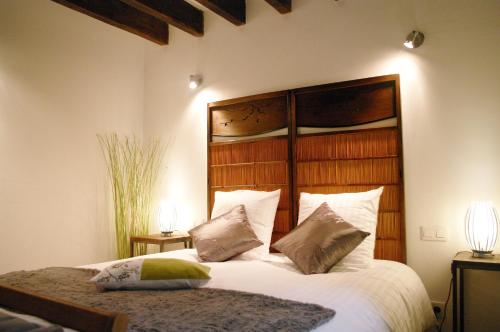 a bedroom with a large bed with white sheets and pillows at Escalebelair in Fontenay-lès-Briis