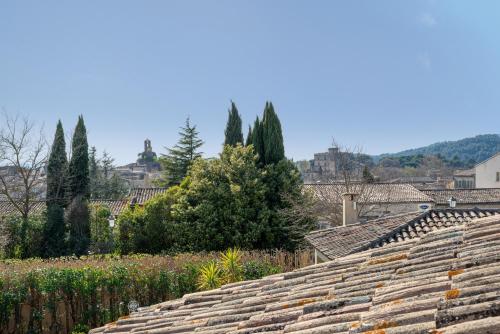 a group of roofs with trees in the background at Hotel Bastide & SPA - Villa de Lourmarin in Lourmarin