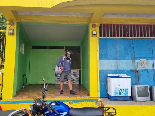 un hombre parado en la puerta de un edificio en Jethro's Staycation&resto, en Maniwaya