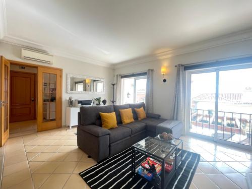 a living room with a couch and a table at Sea and Sun 4 You - Palheiro Village in Funchal
