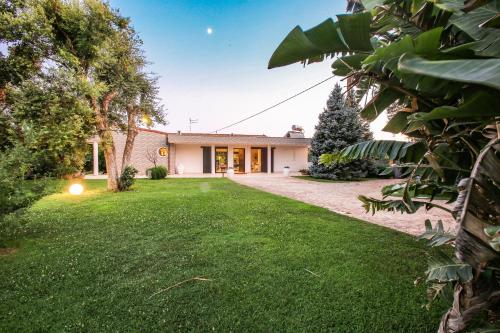 una vista exterior de una casa con patio en Villa con parco e piscina en San Michele Salentino