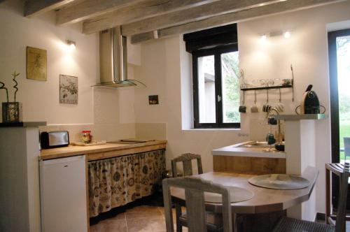 a kitchen with a counter and a sink and a table at Escalebelair in Fontenay-lès-Briis