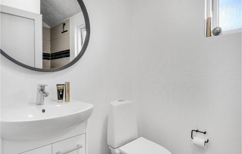 a white bathroom with a sink and a mirror at Lovely Home In Tisvildeleje With Sauna in Holløselund