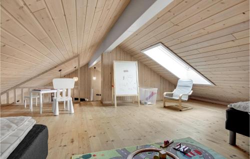 a attic room with a skylight and two chairs and a table at Lovely Home In Tisvildeleje With Sauna in Holløselund