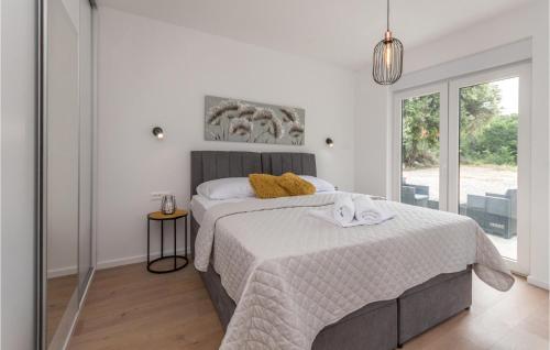 una camera da letto con un letto con lenzuola bianche e una finestra di Villa Danijela a Polača