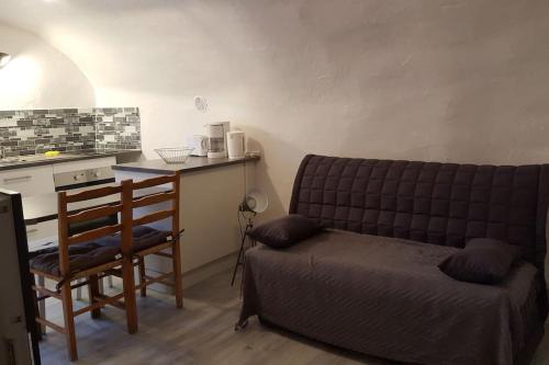 a bedroom with a couch and a table and a chair at GITE RUPICAPRA MERCANTOUR in Roubion