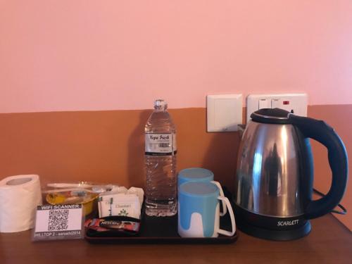 a tea kettle and a bottle of water on a table at Hilltop Restaurant and guesthouse in Pokhara