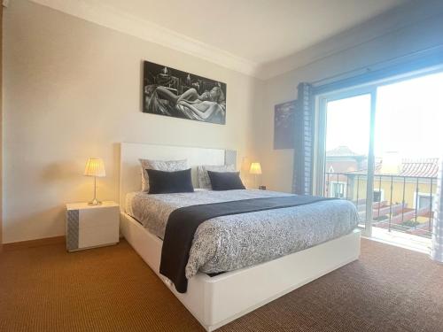 a bedroom with a bed and a large window at Sea and Sun 4 You - Palheiro Village in Funchal