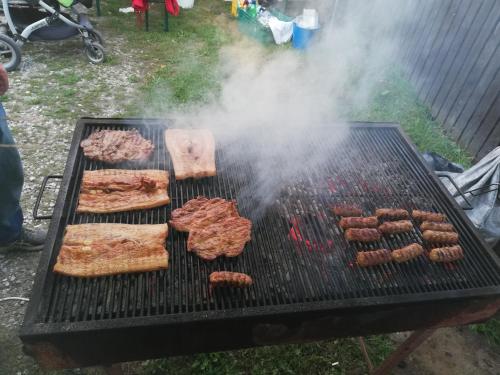 Ein Grill mit einem Haufen Fleisch und Brot drauf. in der Unterkunft Barátság Panzió - Pensiunea Barátság in Ditrău