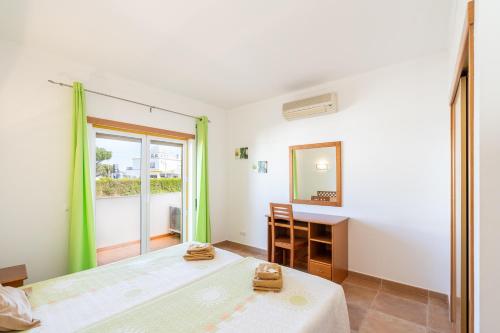 a bedroom with a bed and a desk and a mirror at Recanto da Galé by Umbral in Albufeira