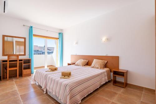 sypialnia z łóżkiem z biurkiem i oknem w obiekcie Recanto da Galé by Umbral w Albufeirze