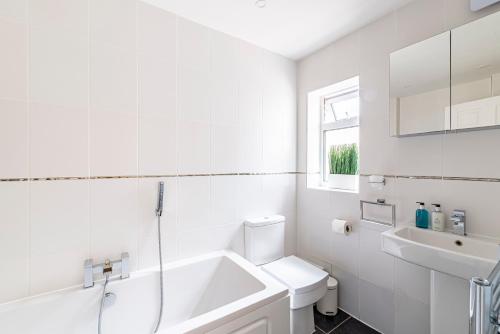 a white bathroom with a sink and a toilet at Greyfriars in Clacton-on-Sea