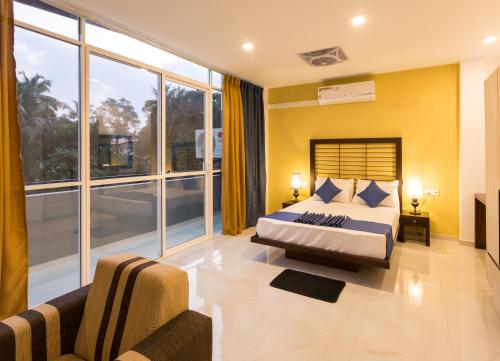 a bedroom with a bed and a couch and windows at Niwahas Apartments Kottawa in Pannipitiya