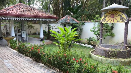 a garden with a gazebo and a bird bath at Angelica Villa in Bentota