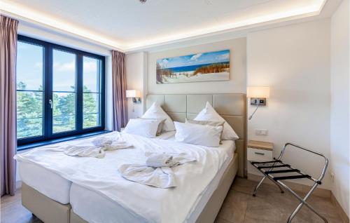 a bedroom with a large white bed and a chair at Cloud in Binz