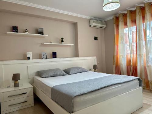 een slaapkamer met een bed en een raam met planken bij Apartment Centre View New Bazaar in Tirana