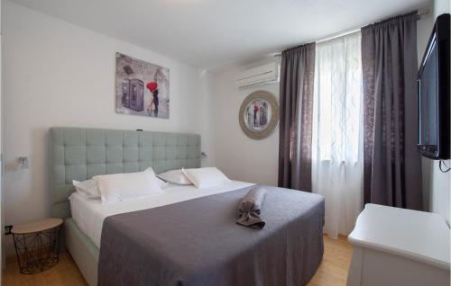 a hotel room with a bed and a television at Beautiful Home In Kalebova Luka With Heated Swimming Pool in Ražanj