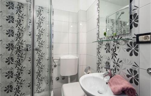 a bathroom with a toilet and a sink and a shower at Beautiful Home In Kalebova Luka With Heated Swimming Pool in Ražanj