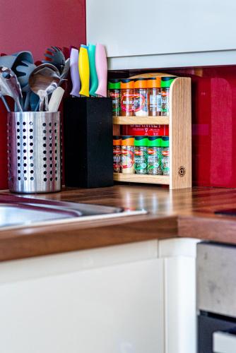a kitchen counter with utensils in a cabinet at Greyfriars in Clacton-on-Sea