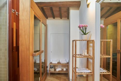 una habitación con estanterías de madera con flores en B&B Le Logge Luxury Rooms, en Siena
