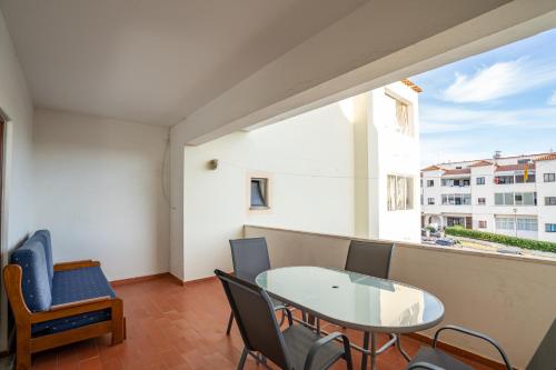 una sala da pranzo con tavolo, sedie e finestra di Apartamento Stª Eulália Deluxe by Umbral ad Albufeira