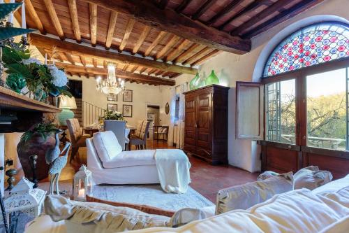 Elle comprend un salon doté d'un mobilier blanc et d'un vitrail. dans l'établissement Villa Viola Residenze Seicento, à Capannori