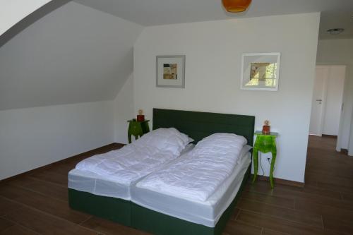 ein großes Bett in einem Zimmer mit 2 Tischen in der Unterkunft Hus Tina Rügen in Trent